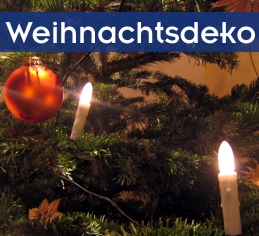 Bildausschnitt rote Christbaumkugel und 2 elektrische Kerzen am Christbaum